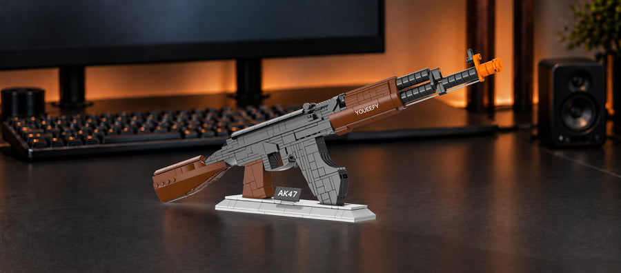 YOUEEFY brown and black AK-47 brick rifle model with an orange muzzle on a display stand