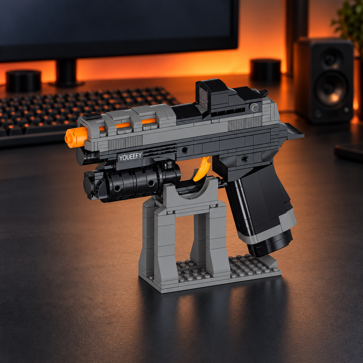 YOUEEFY gray and black brick pistol model with an orange muzzle and trigger displayed on a desk